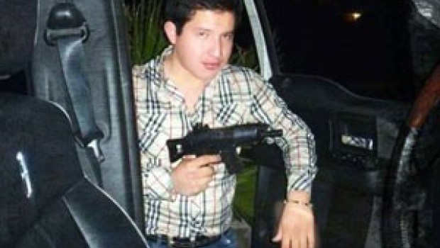 Cachan a hijo de Ramiro Pluma, candidato priista a alcaldía de Tlaxcala, posando con ametralladora
